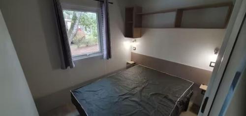 une chambre avec un lit dans une chambre avec une fenêtre dans l'établissement Mobil-home climatisé 6 personnes, à Lège-Cap-Ferret