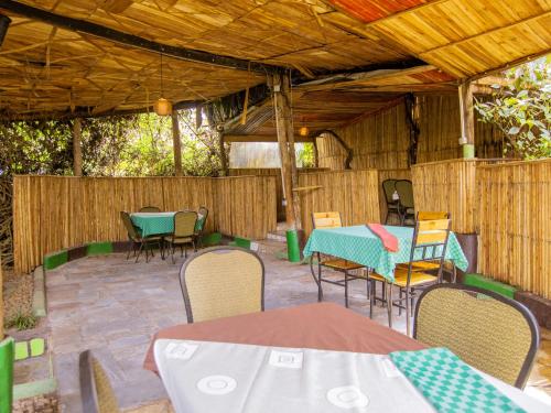 a patio with tables and chairs and a wooden roof at Hotel Saint jean Leopold Apartment in Kigali