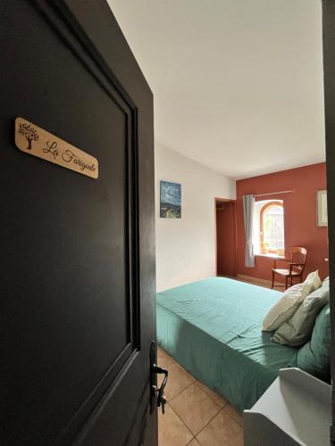 a bedroom with a bed and a door with a sign at Auberge La Tournelle in Saint-Jean-de-Valériscle