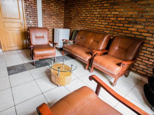 two leather chairs and a table in a waiting room at Hotel Saint jean Leopold Apartment in Kigali