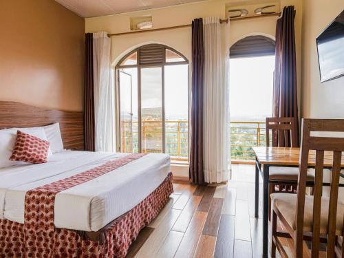 a hotel room with a bed and a desk and window at Hotel Saint jean Leopold Apartment in Kigali