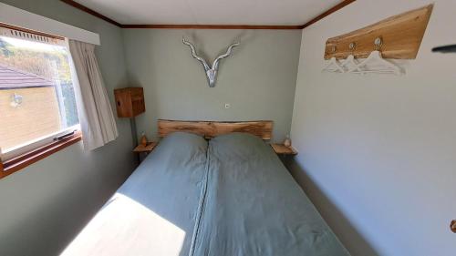 a small bedroom with a bed with a antelope head on the wall at Waterlodge met waterfiets op monumentaal fort in Ooltgensplaat