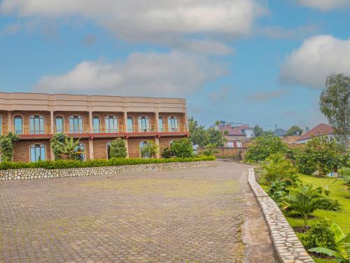 a large brick building with a stone driveway at Hotel Saint jean Leopold Apartment in Kigali