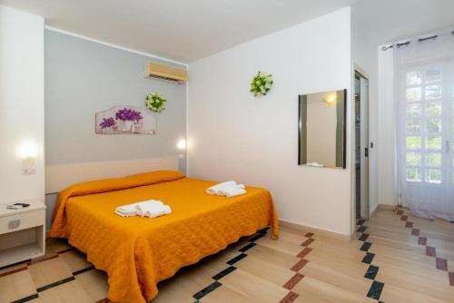 a bedroom with a bed with two towels on it at Hotel sul Mare e Lido Atena in Paestum