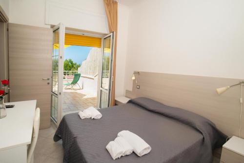 a bedroom with a bed with two towels on it at Hotel sul Mare e Lido Atena in Paestum