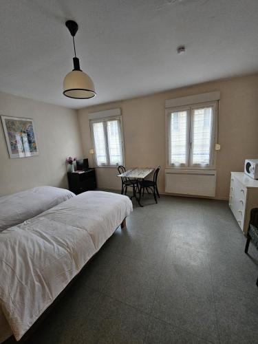 a bedroom with two beds and a table and chairs at Résidence Anclo in Rennes-les-Bains