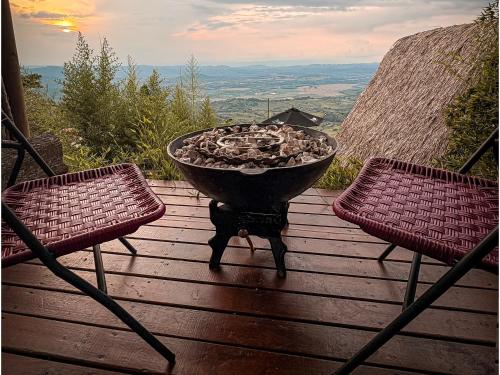 a fire pit sitting on a deck with two chairs at La Cima Eco Hotel in Buenavista