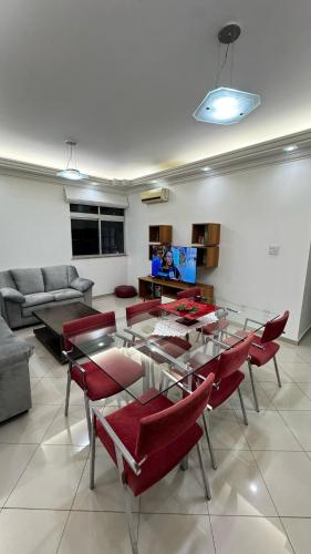 a living room with a table and red chairs at Ueoka Apartment - Hangar Belém in Belém
