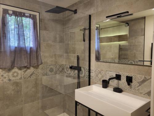 une salle de bain avec un lavabo et un miroir dans l'établissement Maison au calme absolue, à Saint-Cézaire-sur-Siagne