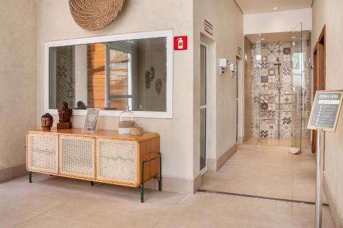 a hallway with a dresser and a mirror in a room at Hotel Serra da Estrela in Campos do Jordão