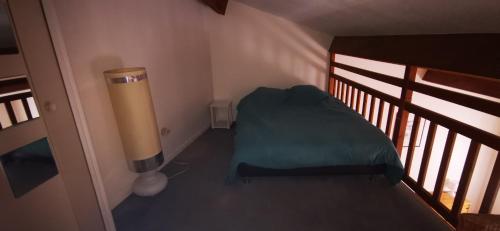 a small room with a bed and a heater at Résidence Anclo in Rennes-les-Bains