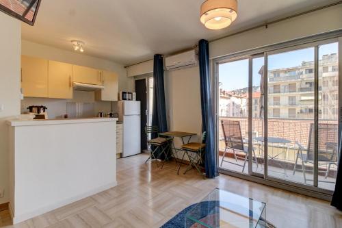 une cuisine avec un comptoir et une grande fenêtre dans l'établissement Cozy Apt with balcony - Garibaldi Port, à Nice