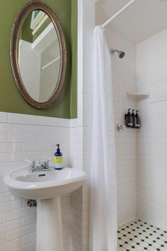 a white bathroom with a sink and a mirror at Chateau Tivoli Bed and Breakfast in San Francisco
