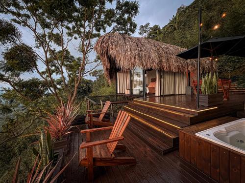 a deck with chairs and a hut with a tub at La Cima Eco Hotel in Buenavista
