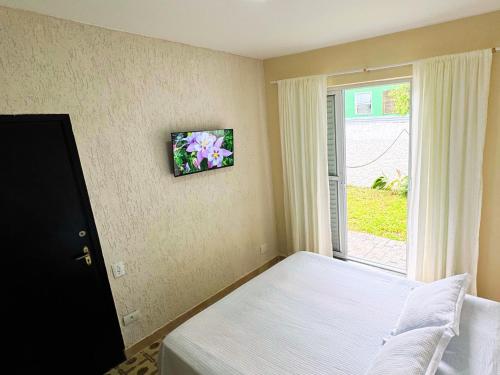 a bedroom with a bed and a window at Tombo Beach in Guarujá