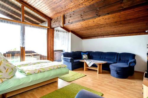 Una sala de estar con un sofá azul y una mesa. en Peaceful Mountain Retreat Simple and Spacious, en Kleinsonnberg