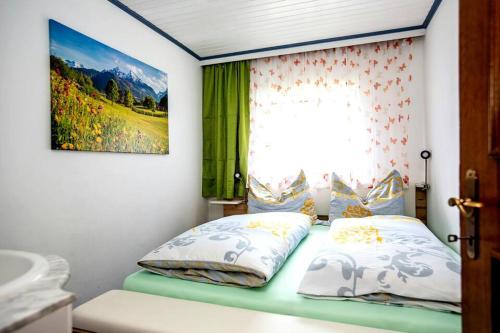 1 cama con 2 almohadas y una ventana en una habitación en Peaceful Mountain Retreat Simple and Spacious, en Kleinsonnberg