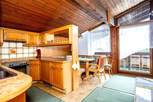 Una cocina con gabinetes de madera y un comedor con mesa. en Peaceful Mountain Retreat Simple and Spacious, en Kleinsonnberg