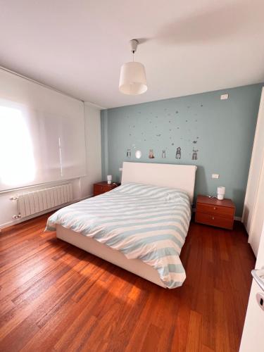 una camera da letto con un letto grande e pavimenti in legno di Appartamento Da Mario a Udine