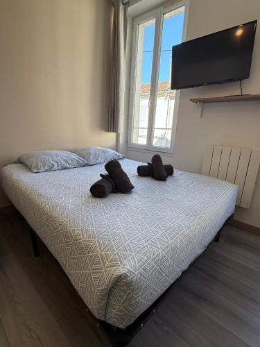 un lit dans une chambre avec deux chapeaux dessus dans l'établissement LeSimplicity #CentreVille, à Cognac