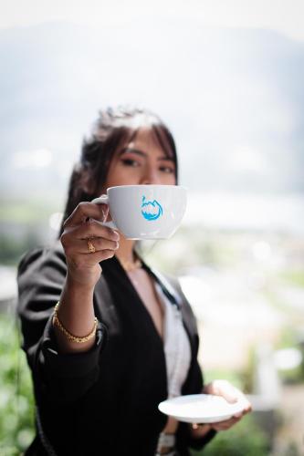a woman holding a cup with a fish on it at Hospedaje Vertientes del Imbabura in Otavalo