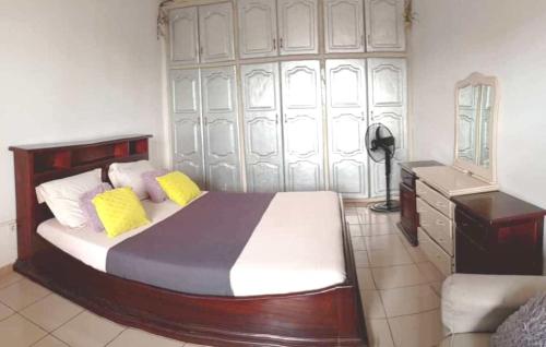 a bedroom with a bed and a desk and a mirror at Cybhouse in Yaoundé