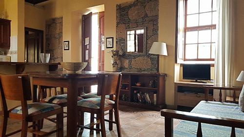 uma sala de jantar com uma mesa e cadeiras e uma televisão em Casa Rural El Traspatio em Granadilla de Abona