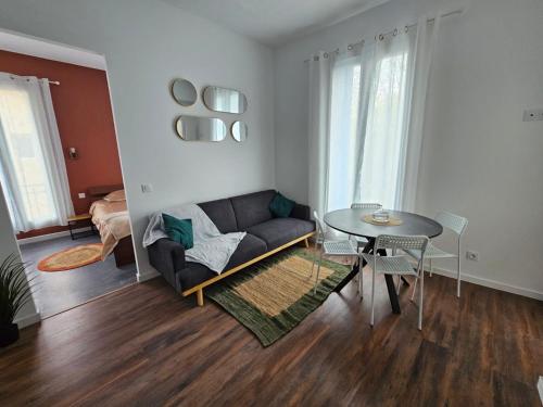 a living room with a couch and a table at Les sureaux, le charme du centre de perpignan in Perpignan