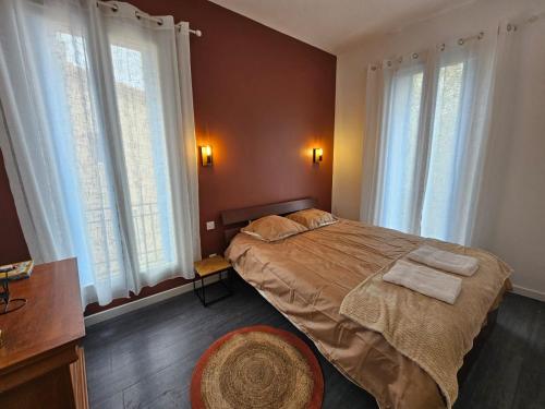 a bedroom with a bed with two towels on it at Les sureaux, le charme du centre de perpignan in Perpignan