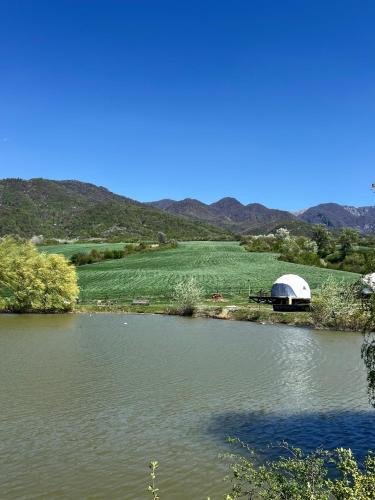 a dome tent sitting next to a body of water at Chadir yurd glamp in İsmayıllı