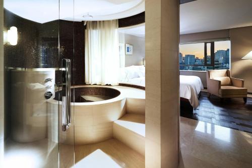 a bathroom with a tub and a bedroom with a bed at Westin Josun Seoul Hotel in Seoul