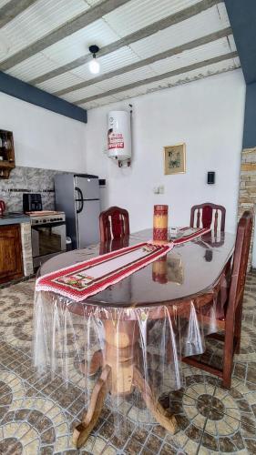 a table in a kitchen with red chairs around it at Alojamiento Itaembe Guazu in Villa Dolores