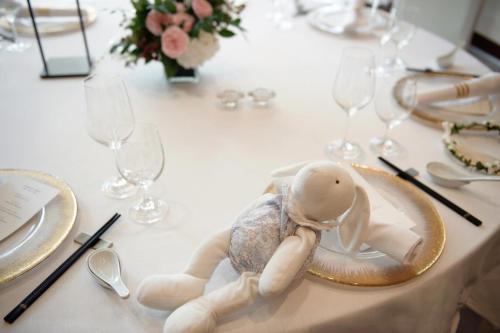 a doll sitting on a plate on a table with glasses at Westin Josun Seoul Hotel in Seoul