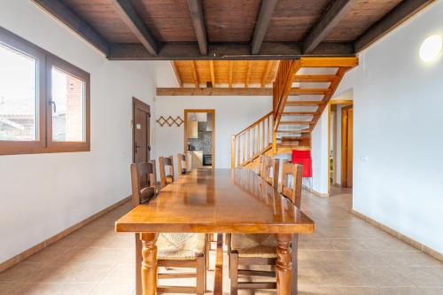 a dining room with a wooden table and chairs at Can Prats in Ríudecañas