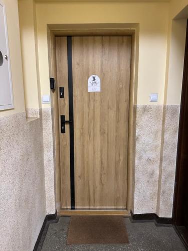 a wooden door with a sign on it in a building at Studio Orzeł Biały in Bytom