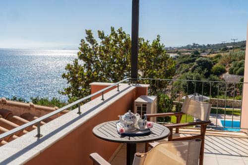 a table on a balcony with a view of the water at Villa Brio in Skala Kefalonias