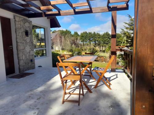 a wooden table and chairs on a patio at La Juanita in Sierra de los Padres