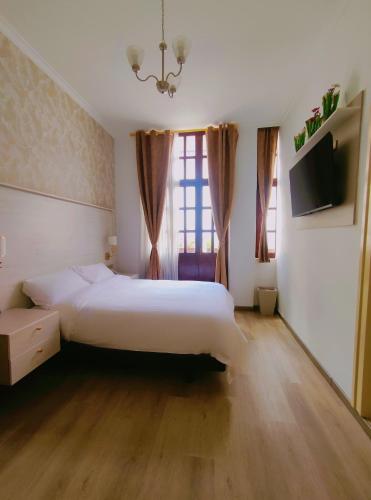 a bedroom with a white bed and a large window at Hotel Sucre in Quito