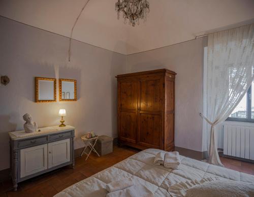 a bedroom with a bed and a dresser and a window at Casa il Castello in Gambassi Terme