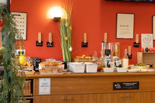 a buffet with food on a counter with orange walls at ibis Le Puy-en-Velay Centre in Le Puy en Velay