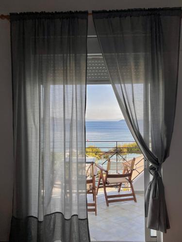 a room with a window with a view of the ocean at Lenio Rooms in Skiathos Town