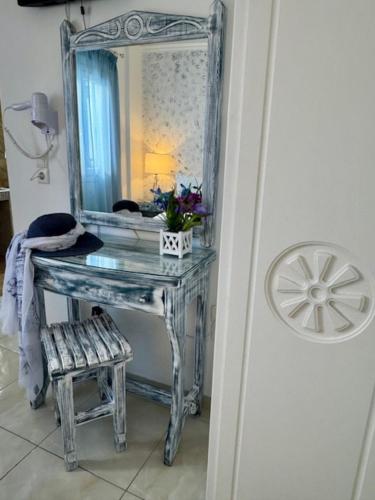 a blue dressing table with a mirror and a stool at Phoenix in Fira