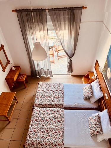 a bedroom with two beds and a window at Lenio Rooms in Skiathos Town