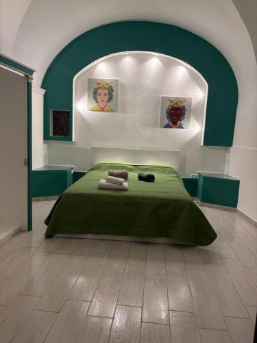 a bedroom with a green bed with towels on it at La maison des marins in Catania