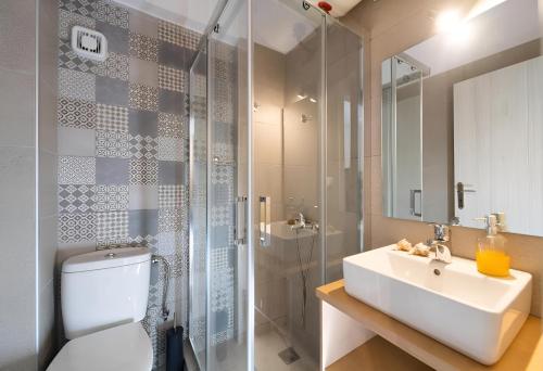 a bathroom with a toilet and a sink and a shower at Melodia Lefkada Apartment 2 in Nikiana