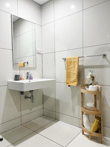 a white bathroom with a sink and a mirror at C&J city centre Airbnb in Windhoek