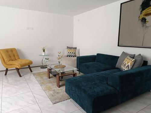 a living room with a blue couch and a chair at Gran departamento de lujo ejecutivo con alberca in Sanctórum