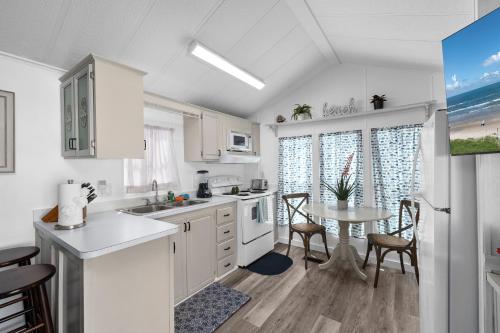 a kitchen with white cabinets and a table with chairs at LIV Resort, Private Jacuzzi and Pet Friendly in Port Isabel