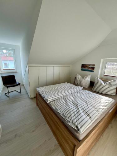 a bedroom with a bed and a chair in it at Schlösschen am Schmachter See in Binz