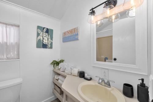 a white bathroom with a sink and a mirror at LIV Resort, Private Jacuzzi and Pet Friendly in Port Isabel